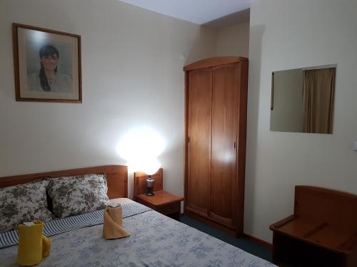 a bedroom with a bed and a wooden cabinet at Boeritza Hotel Complex in Vladaya