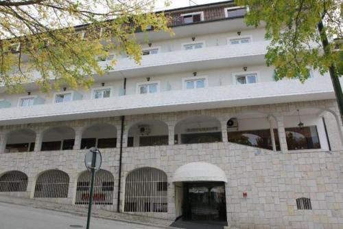 un gran edificio blanco con muchas ventanas en Petrus Hotel en Chaves