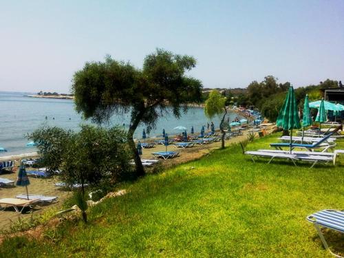 a beach with chairs and umbrellas and the water at Artemis Boutique Apartment 1 in Limassol