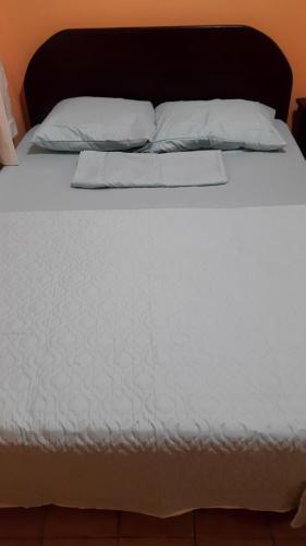a white bed with white sheets and pillows at Hotel Latino in San José