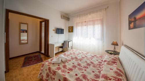 a bedroom with a bed and a window and a desk at La Castellese in Aci Castello