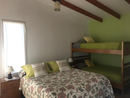 a bedroom with a bed and two bunk beds at Las Hualas in Punta de Choros