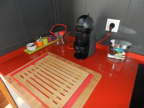 a red counter top with a cutting board and a coffee maker at Vale Dos Milhafres in Angra do Heroísmo