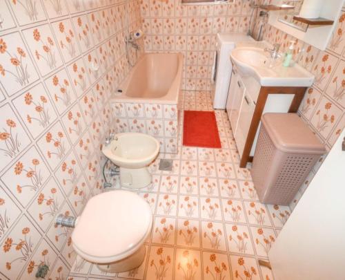 a bathroom with a toilet and a sink and a tub at Apartment Villa Venezia in Perast
