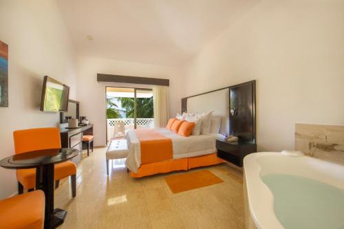 a bedroom with a bed and a bath tub at Viva Dominicus Palace by Wyndham, A Trademark All Inclusive in Bayahibe