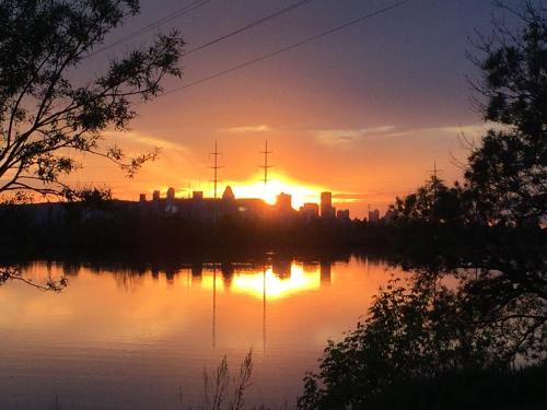 a sunset over a lake with a city in the background at Motel Du Fleuve in Brossard