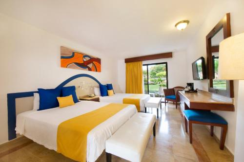 a hotel room with two beds and a desk at Viva Dominicus Palace by Wyndham, A Trademark All Inclusive in Bayahibe
