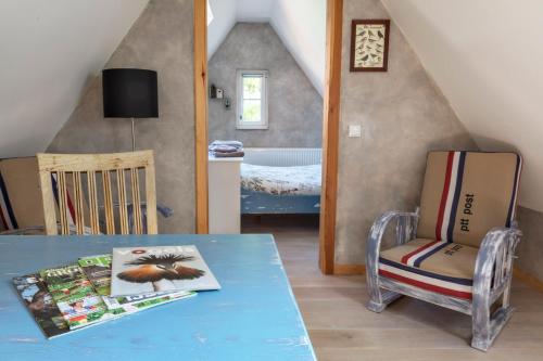 a room with a table and a chair and a bedroom at Bosgasten in Putten