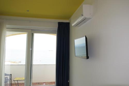 ヴィエトリにあるCasa Amorevoleの壁にテレビが備わる窓付きの客室です。