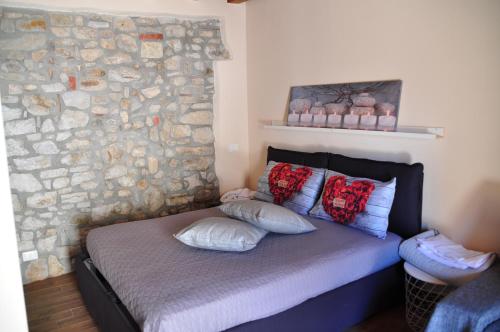 1 dormitorio con pared de piedra y 1 cama con almohadas en Villetta in Centro Storico en Caccamo