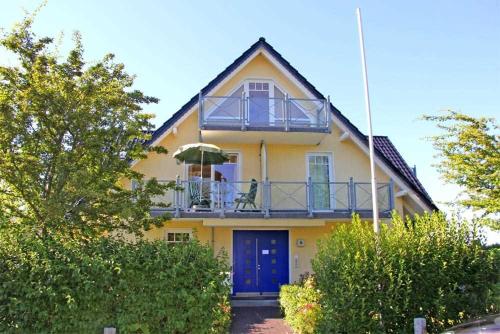 オストゼーバート・ニーンハーゲンにあるFerienwohnung Nienhagen MOST 2170の黄色の家(バルコニー付)