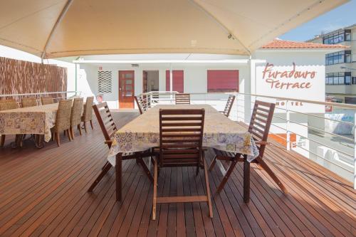 a table and chairs on the deck of a cruise ship at Furadouro Terrace Hostel in Furadouro