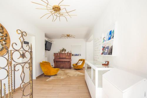 a living room with a chandelier and yellow chairs at Furadouro Terrace Hostel in Furadouro