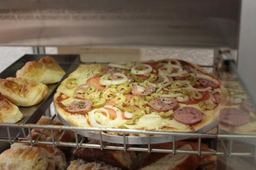 a pizza sitting on top of a rack in an oven at Hotel Cco Goiânia in Goiânia
