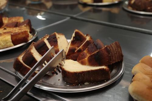 a plate of waffles with a fork and a plate of bread at Hotel Cco Goiânia in Goiânia