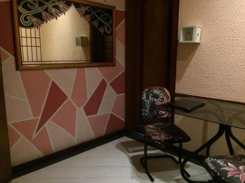 uma cadeira sentada ao lado de um espelho num quarto em Hotel Free (Adult Only) no Rio de Janeiro