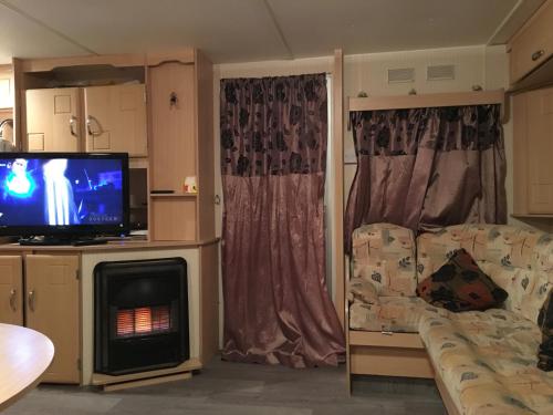 a living room with a couch and a flat screen tv at 4 bedroom caravan ingoldmells skegness in Ingoldmells