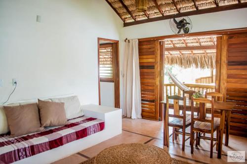 a bedroom with a bed and a table and chairs at Residence Bons Ventos Jeri in Jericoacoara