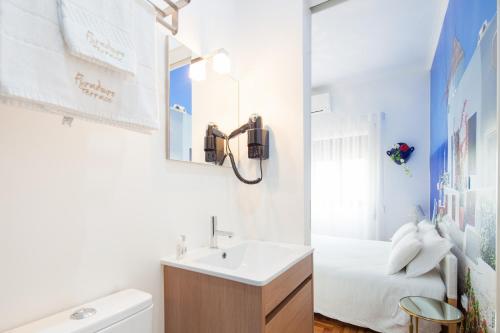 a white bathroom with a sink and a bed at Furadouro Terrace Hostel in Furadouro