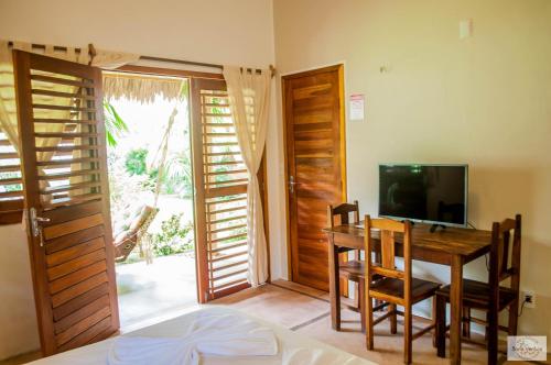 a bedroom with a dining room table and a television at Residence Bons Ventos Jeri in Jericoacoara