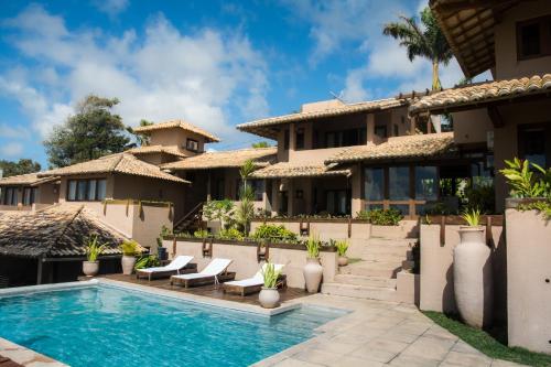 a villa with a swimming pool and a resort at Baixu Village in Arraial d'Ajuda