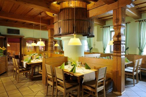 ein Esszimmer mit Tischen und Stühlen in einem Restaurant in der Unterkunft Landhotel Schlappinger-Hof in Reisbach