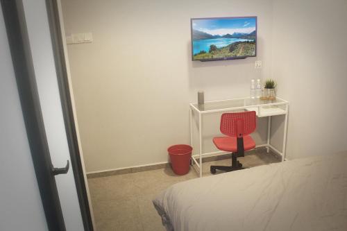 a bedroom with a bed and a desk and a red chair at Vertilex Hotel in Johor Bahru