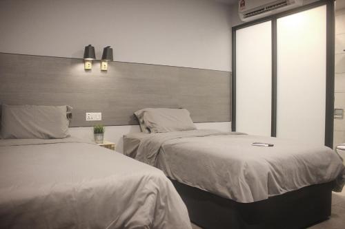a bedroom with two beds and a large window at Vertilex Hotel in Johor Bahru