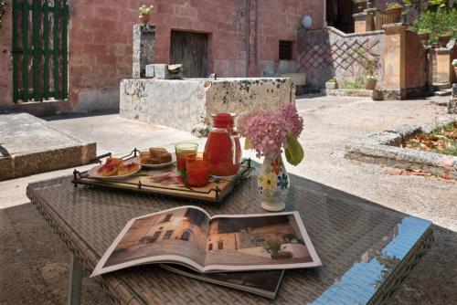 un tavolo con un libro e un piatto di cibo di Palazzo Laura a Morciano di Leuca