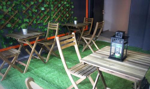 a group of tables and chairs and a wooden bench at Vertilex Hotel in Johor Bahru