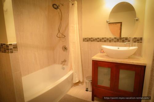 a bathroom with a sink and a tub and a mirror at The Quail's Nest Retreat in Point Reyes Station