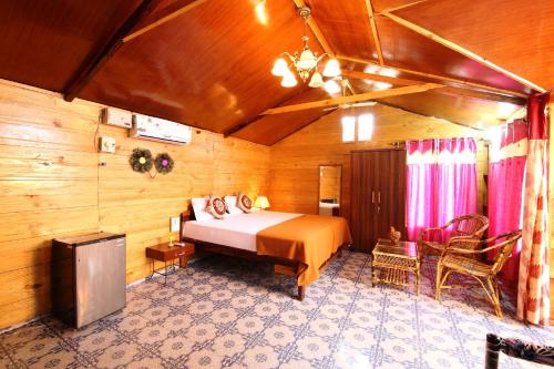 Un dormitorio con una cama en una habitación de madera. en Agonda Holiday Home, en Agonda
