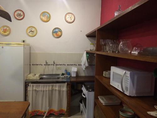 a kitchen with a sink and a microwave at Conforto e Charme em Ilhabela in Ilhabela