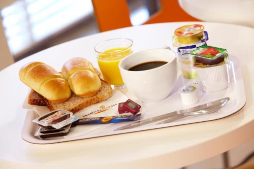 a breakfast tray with bread and coffee on a table at Premiere Classe Beauvais in Beauvais