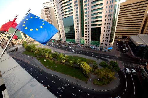 a european flag flying over a street with buildings at White Fort Hotel in Dubai