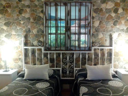 a bedroom with two beds and a window at Toño el Alguacil in Selaya
