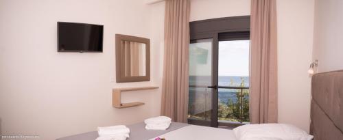 a bedroom with a bed and a large window at Life's Moments in Limenaria