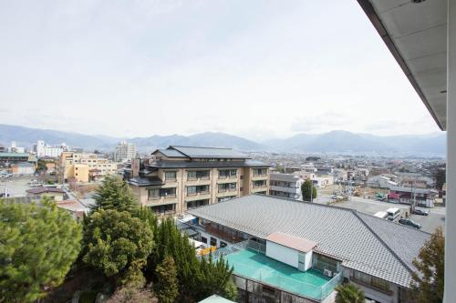 a city with buildings and mountains in the background at Hotel Heian in Fuefuki