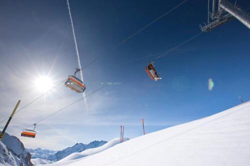 a ski lift going up a snow covered slope at Chasa Castello relax & spa in Samnaun