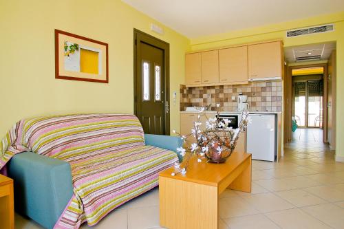 a living room with a couch and a kitchen at Aegean Dream Hotel in Karfas