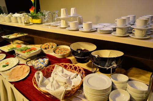a buffet with white plates and dishes on a table at Nadine Hotel Suites in Amman