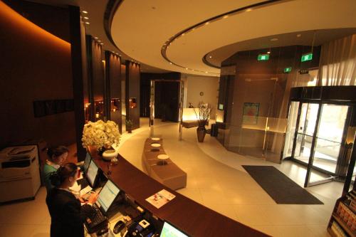 a lobby of a building with two people at a counter at Goldmet Inn Changzhi Bayi Square in Changzhi