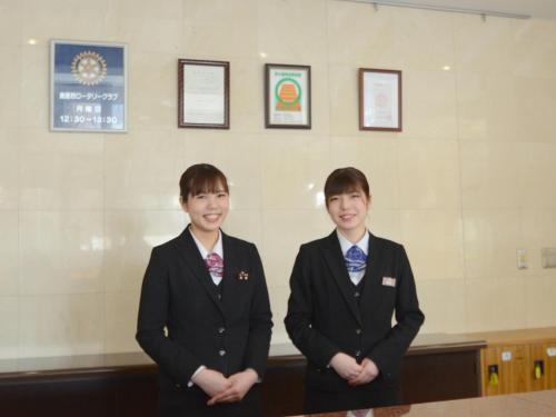 two young boys in suits standing in a room at Hotel Satsukien in Kanoya