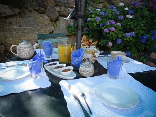 Chambres d'Hôtes Le Crouzat في Empurany: طاولة عليها صحون واكواب ومشروبات