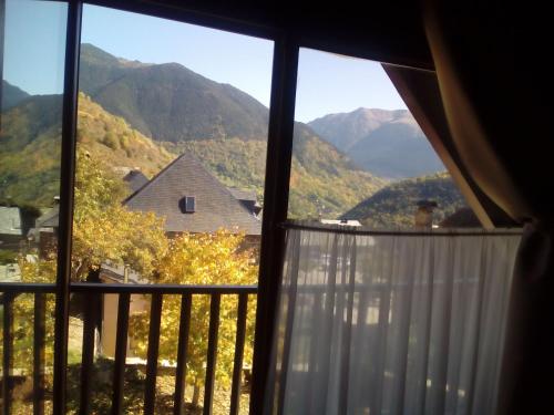 a room with a view of mountains from a window at Hotelet de Betlan in Betlán