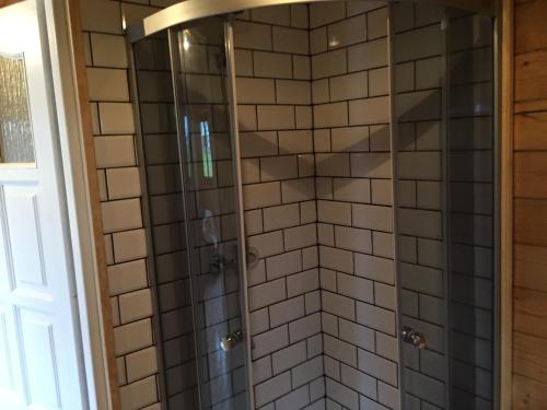 a shower with gray and white tiles in a bathroom at Camping Szczecinek Domy Wypoczynkowe in Szczecinek