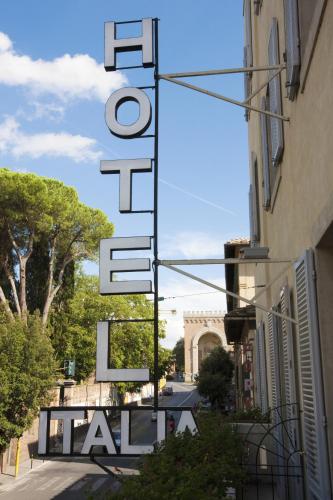 a sign for a hotel on a street next to a building at Hotel Italia in Siena