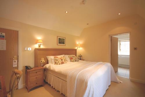 a bedroom with a large bed and a wooden dresser at Losehill House Hotel & Spa in Hope
