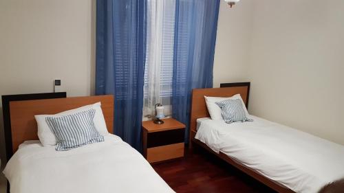um quarto com 2 camas e uma janela com cortinas azuis em Casa Branca Apartment no Funchal