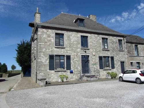 a white car parked in front of a stone house at Les Glaneuses in Mettet